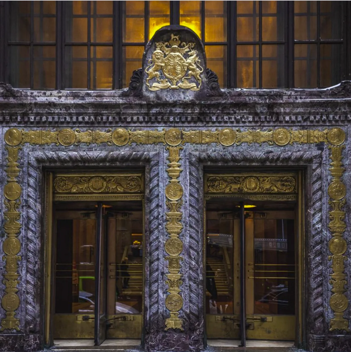 Marble entrance portal with gilded royal crest